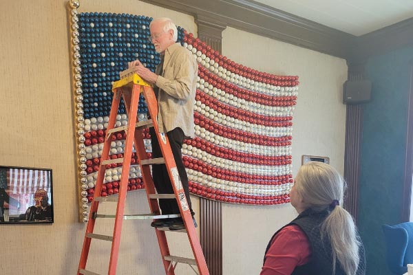 Taking each glass bulb out of the flag at the Penn Wells Hotel to be cleaned